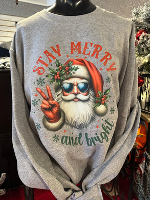 Gray sweatshirt with an illustration of Santa Claus making a peace sign, surrounded by holiday-themed decorations.
